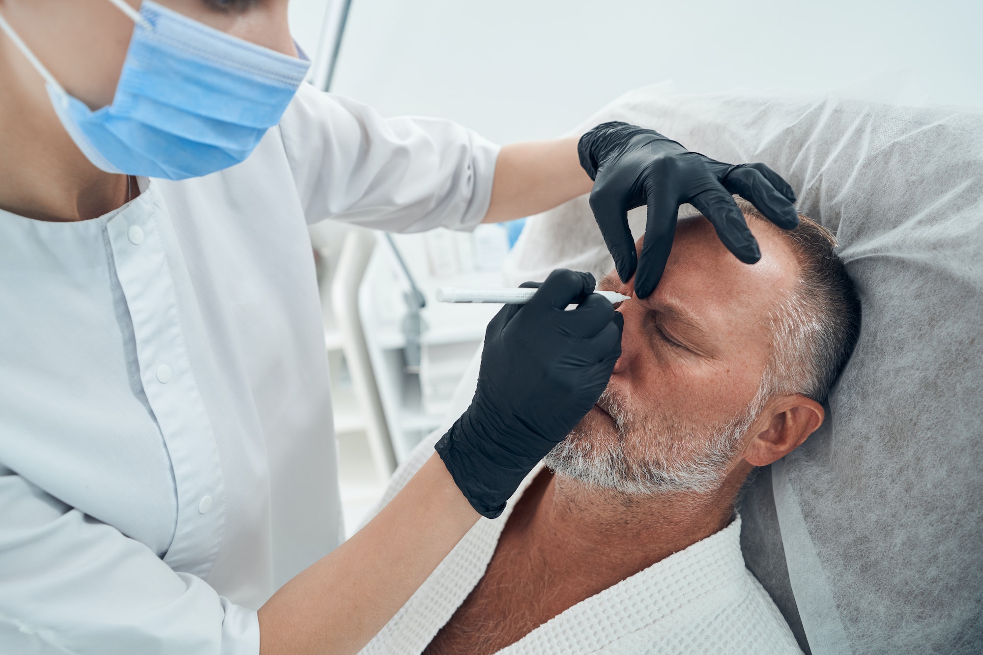 Man having skincare procedure in cosmetology clinic